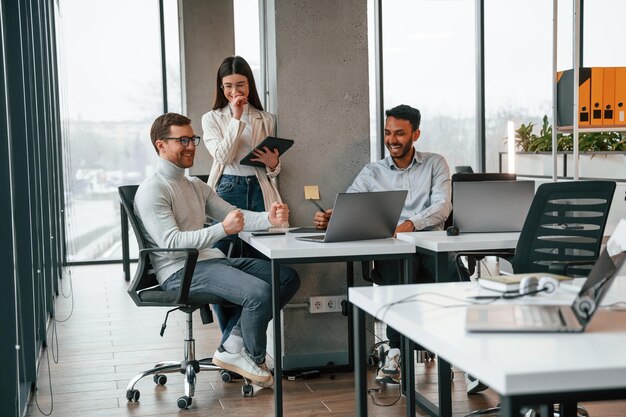 Smiling and talking Men and woman are working in the office together