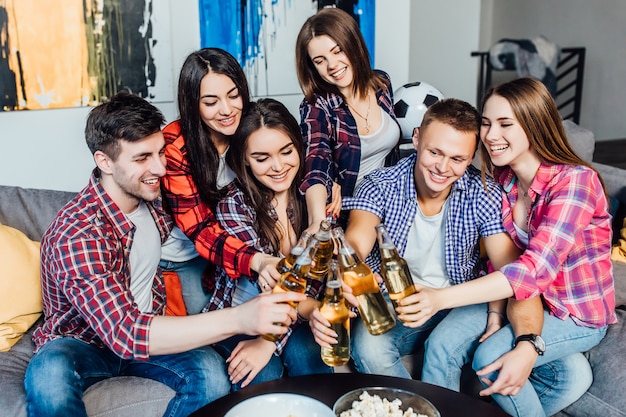 Smiling team of workers after job relaxed at home with beer.