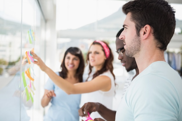 Smiling teamwork reading sticky notes