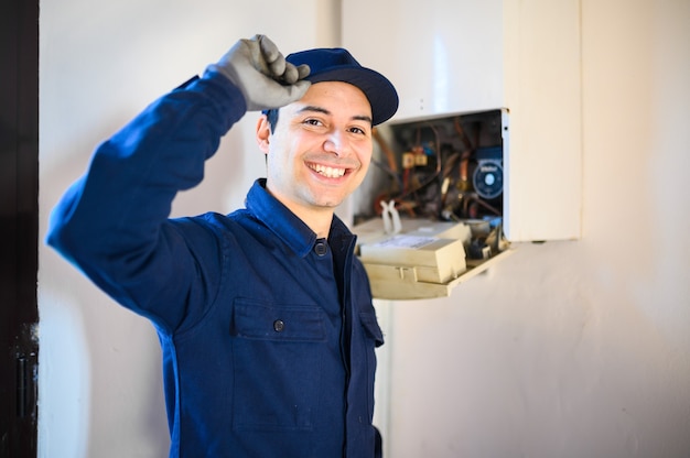 Smiling technician repairing an hot-water heater