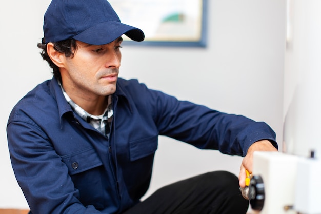 Smiling technician repairing an hot-water heater