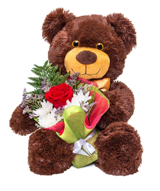 Smiling teddy bear holding beautiful floral bouquet in paws on white background