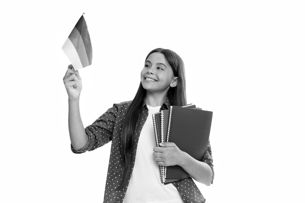 Smiling teen girl hold german flag and workbook schengen countries touristic visa back to school