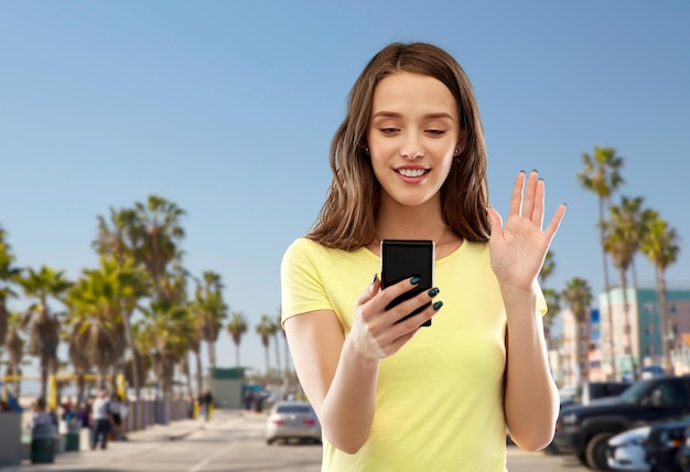 Photo smiling teenage girl having video call smartphone