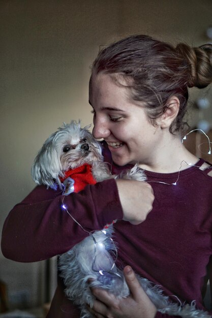 Foto ragazza adolescente sorridente con un cane in mano