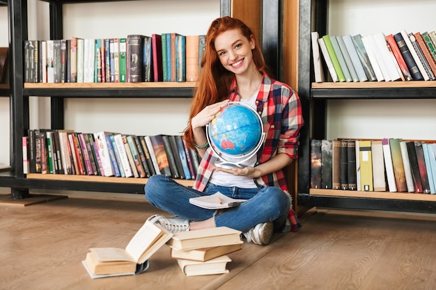 Smiling teenage girl holding globe