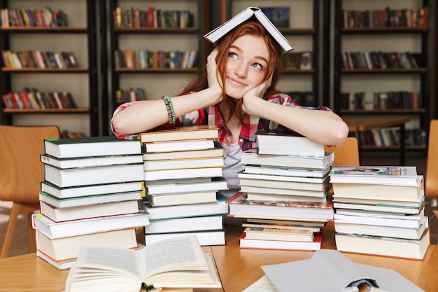 Smiling teenage woman sitting at the library