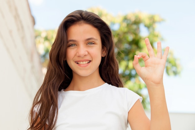 Smiling teenager girl saying ok