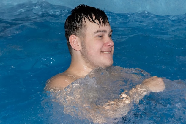 A smiling teenager is swimming in the pool Sports and recreation Healthy lifestyle