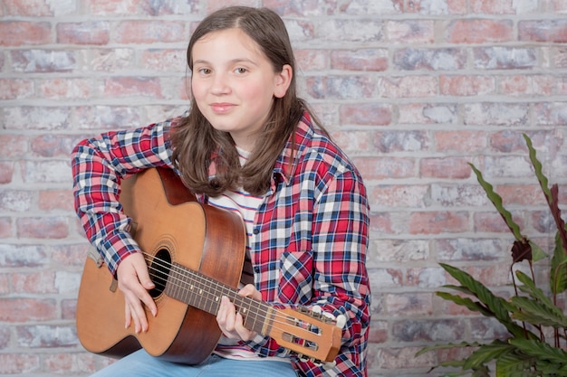 Smiling teenager playing guitar