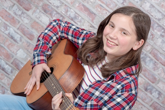 Photo smiling teenager playing guitar