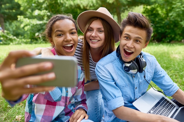 Smiling Teenagers Taking Selfie in Park