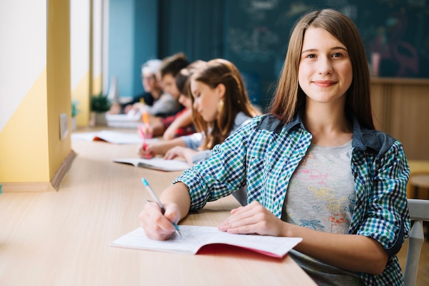 Photo smiling teens at desk