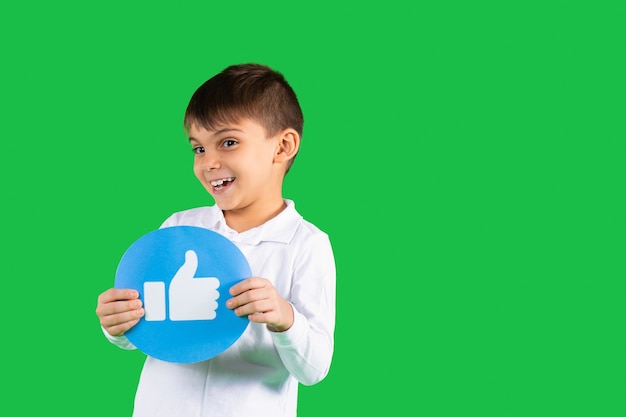 Smiling toddler boy poses with a round banner with thumb up