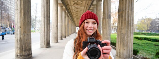 Foto il fotografo turistico sorridente scatta foto durante il suo viaggio con una macchina fotografica professionale e la realizza