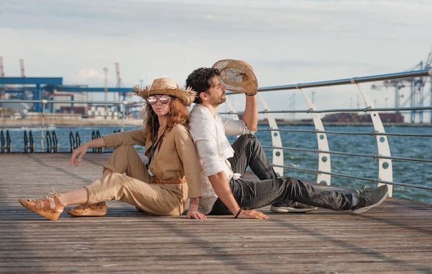 Photo smiling touristic couple posing outdoor near seacost