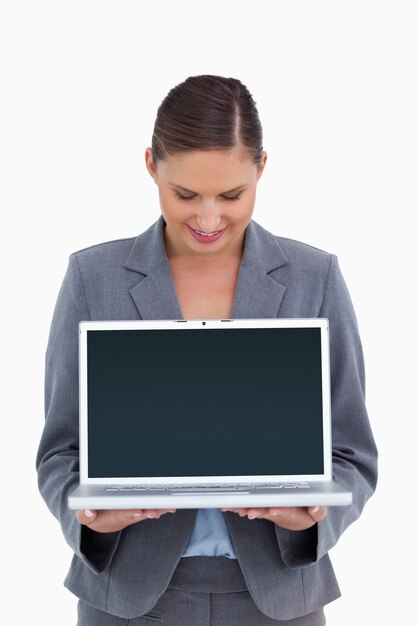 Smiling tradeswoman looking down at her laptop