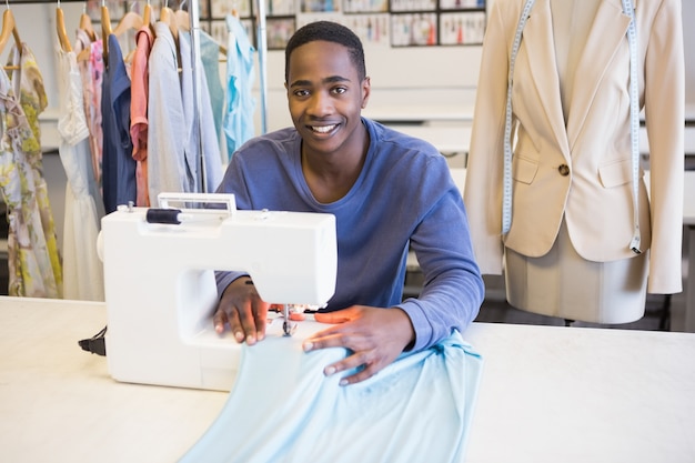 Smiling university student using sawing machine