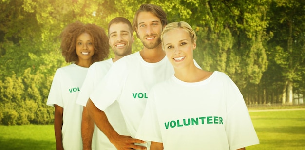 Foto sorridente gruppo di volontari contro alberi e prato