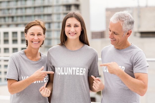 Smiling volunteers pointing on shirt