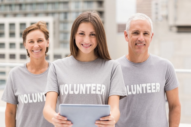 Smiling volunteers with tablet 