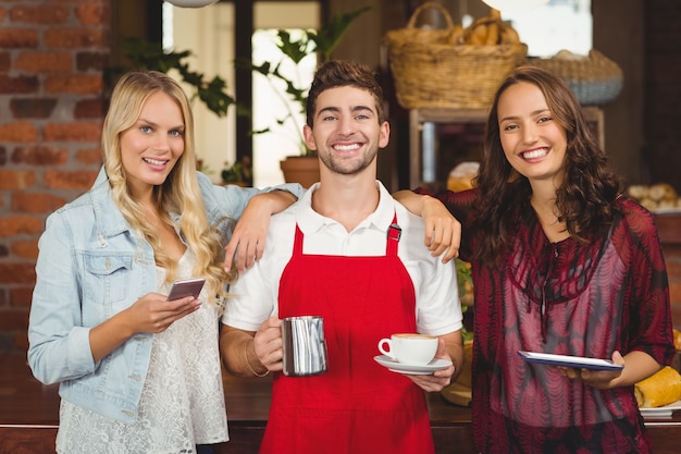 Smiling waiter and customers looking at the camera