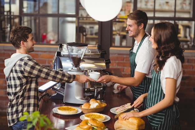 Smiling waiters serving a client