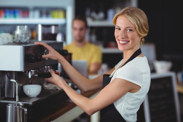 一杯のコーヒーを作る笑顔のウェイトレス