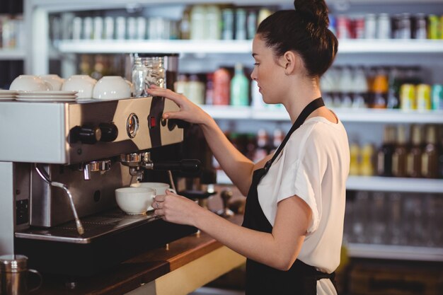 Smiling waitress making cup of coffee