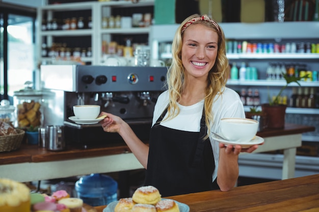 Smiling waitress offering cup of coffee