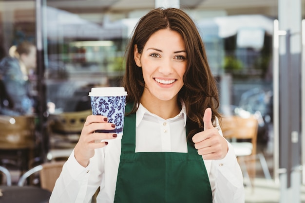 カフェでコーヒーを提供する笑顔のウェイトレス