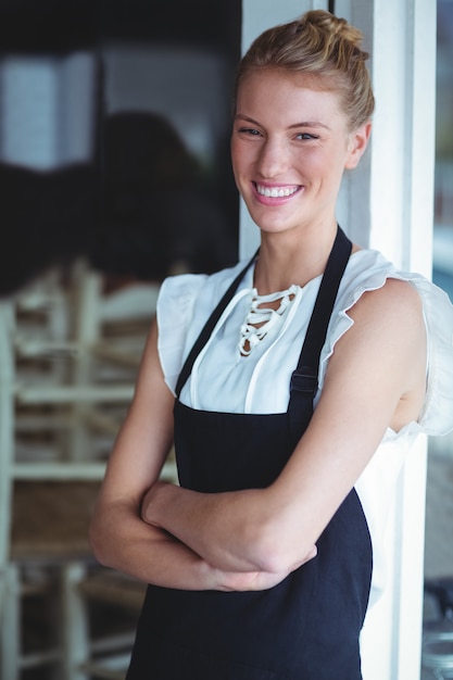  smiling waitress standing with arms crossed