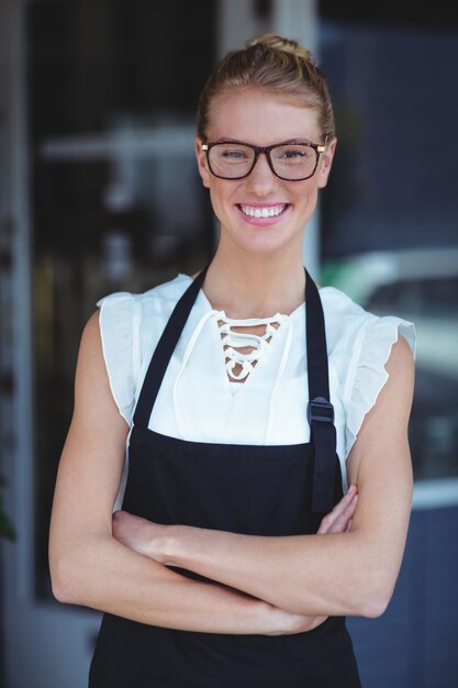 Photo smiling waitress standing with arms crossed