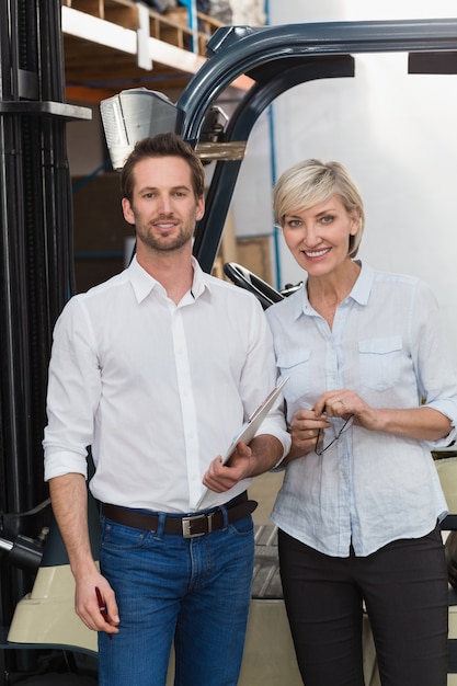 Smiling warehouse managers looking at camera