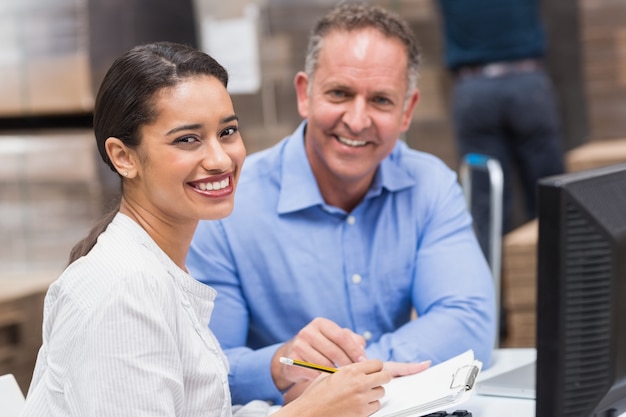 Gestori di magazzino sorridenti che lavorano insieme