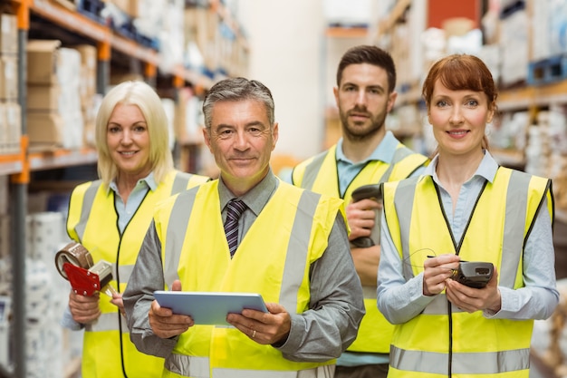 Smiling warehouse team looking at camera