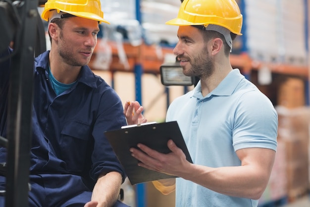 Smiling warehouse workers talking together