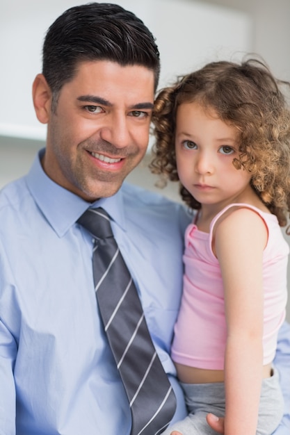 Sorridendo padre ben vestito che porta sua figlia