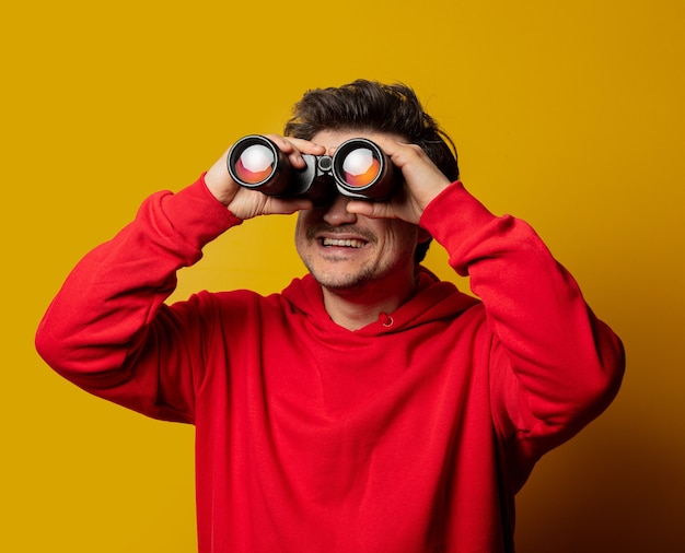 Smiling white guy in rd hoodie with binocular