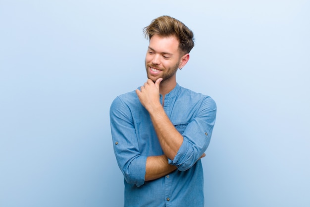 smiling with a happy, confident expression with hand on chin, wondering and looking to the side