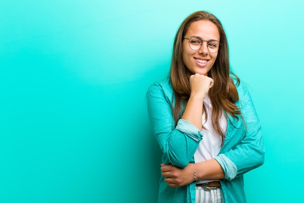 smiling with a happy, confident expression with hand on chin, wondering and looking to the side