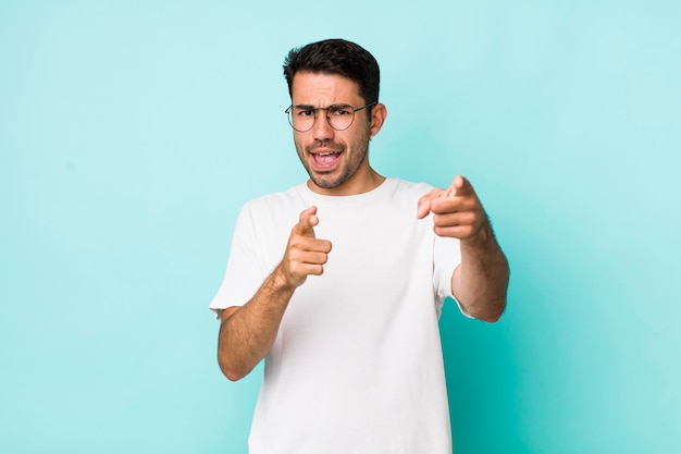 Sorridendo con un atteggiamento felice positivo positivo che punta alla telecamera facendo segno di pistola con le mani