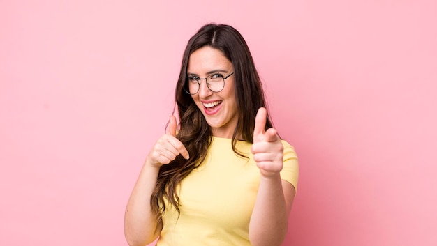 Smiling with a positive successful happy attitude pointing to the camera making gun sign with hands