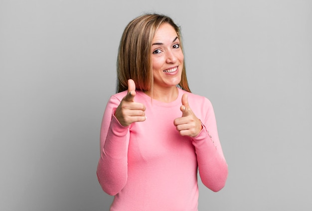 Foto sorridendo con un atteggiamento felice positivo positivo che punta alla telecamera facendo segno di pistola con le mani