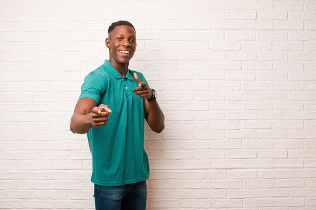 smiling with a positive, successful, happy attitude pointing at front, making gun sign with hands