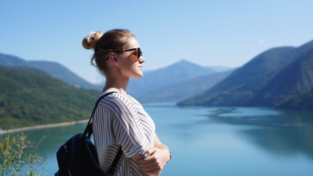 Donna sorridente contro il paesaggio di montagna e il lago