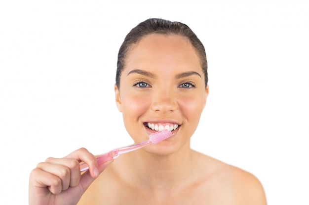 Smiling woman brushing her teeth