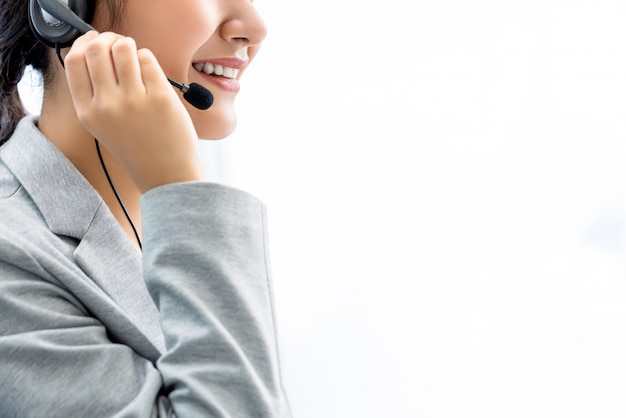 Smiling woman call center staff on white wall with copy space