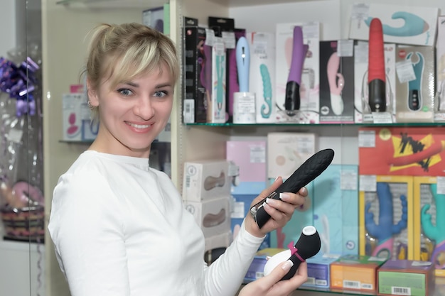 A smiling woman chooses a sex toy Entertainment and recreation Satisfaction and enjoyment