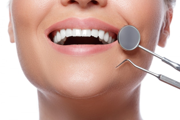 Улыбающиеся женщина и стоматологические инструменты